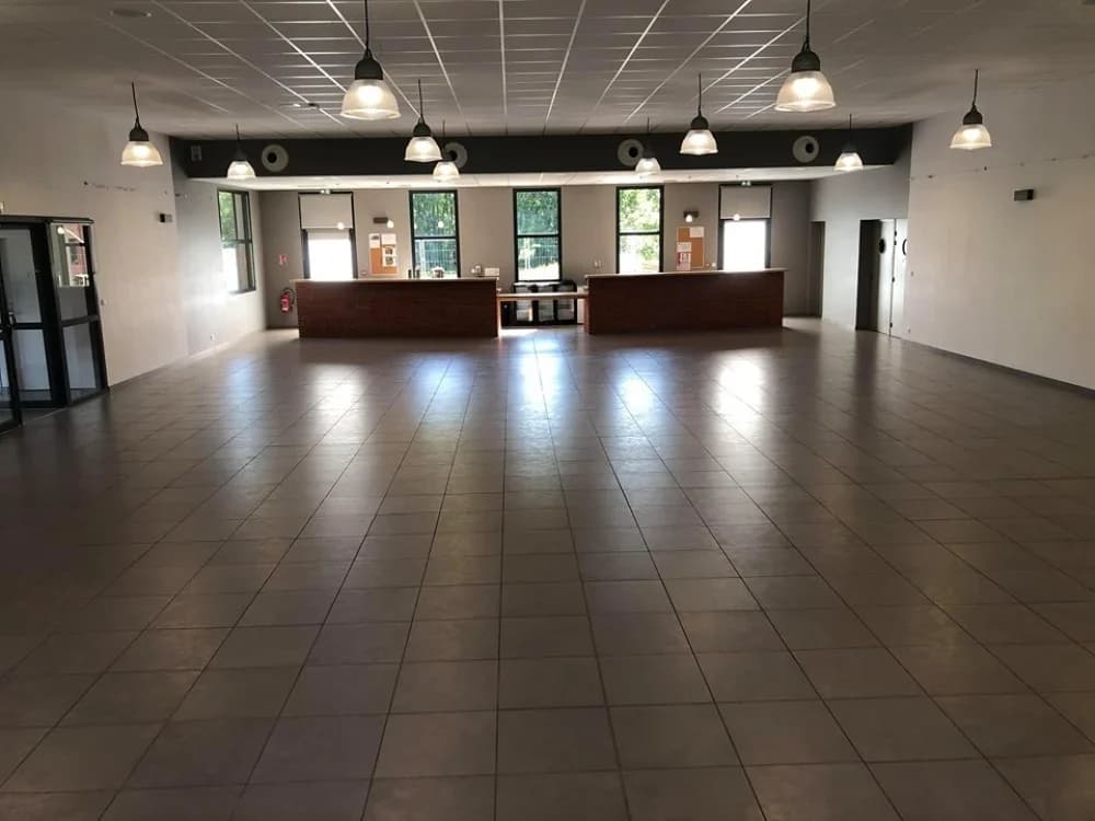 Vue intérieure de la salle des fêtes de Viscomtat : espace de réception avec comptoirs et éclairage